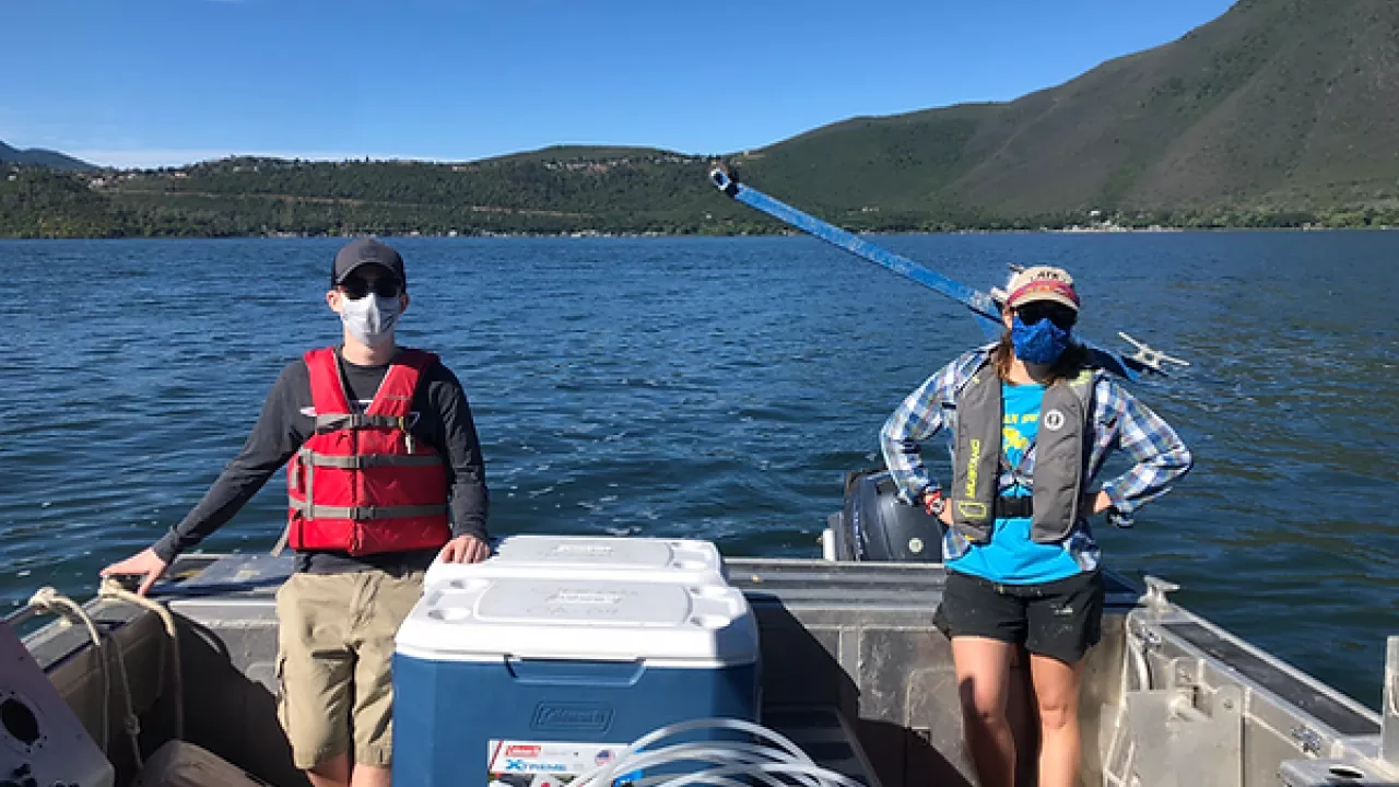Two people with masks on a boat